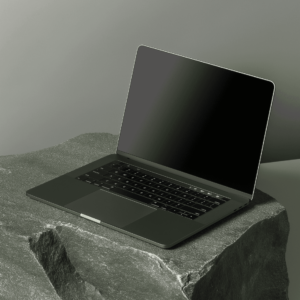 Black laptop computer sitting on a gray rock